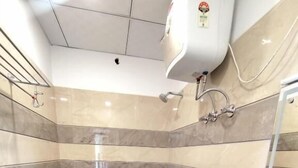 A bathroom with a toilet, sink, and shower. - hotel PS Residency (Dehradun)