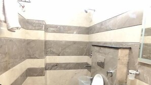 A bathroom with a toilet, sink, and shower area. - hotel PS Residency (Dehradun)