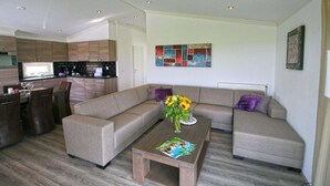 Una sala de estar moderna con un sofá, una mesa de centro y un comedor con sillas y una mesa.