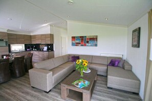Una sala de estar moderna con un sofá, una mesa de centro y un comedor con sillas y una mesa.