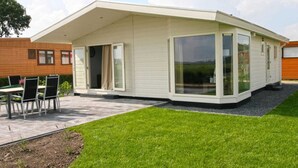 Una casa moderna con un patio, un comedor y grandes puertas correderas de vidrio.