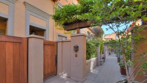 A narrow alleyway with a wooden gate, a metal gate, and a potted plant. - Luxury 2-bedroom townhome with AC in San Jose (San Jose)