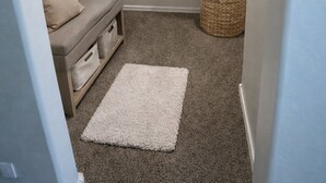 A walk-in closet with hanging clothes, a bench, and storage bins. - Luxury Content, Event and Rental House + Private Chef Experience - Casa Velour (Maricopa)