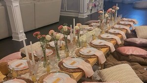 A long dining table set with plates, candles, and flowers, surrounded by cushioned seating. - Luxury Content, Event and Rental House + Private Chef Experience - Casa Velour (Maricopa)