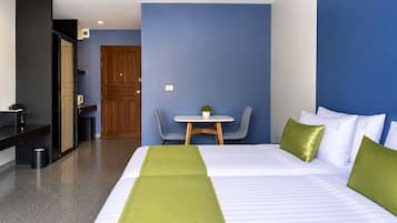 A hotel room with a bed, a desk, and a chair.