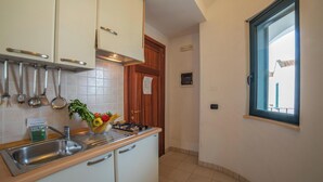 A kitchen with a sink, cabinets, a stove, and a window. - Blumare Apartment 3 Pool & Sea (Otranto)