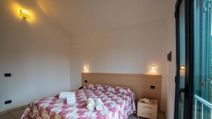 A bedroom with a bed, bedside tables, and a window. - Blumare Apartment 3 Pool & Sea (Otranto)