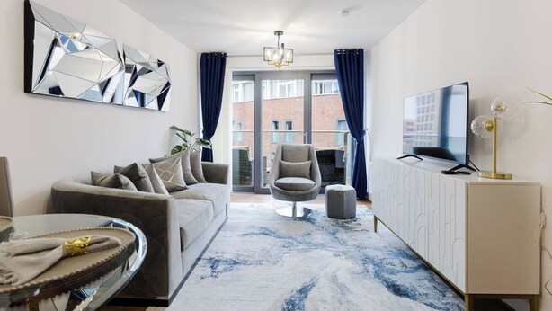Een moderne woonkamer met een bank, een televisie en een kast.