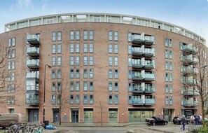 A multi-story building with a curved facade, featuring a series of balconies on each floor. - Beautifully Presented 2BDR Flat in Canada Water (Greater London)