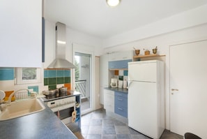 A kitchen with a stove, sink, and cabinets. - Nature Green House by RentalsPro - Akti Elia Halkidiki (Nikiti)
