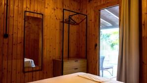 A wooden room with a bed, a dresser, and a mirror. - Casa Mocha by RentalsPro - Vourvourou Halkidiki (Vourvourou)