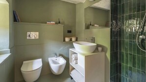 Casa de banho com sanita, bidé e uma grande lavatório.