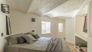 Um quarto com uma cama, um guarda-roupa, uma janela e uma porta.