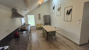 A modern kitchen with a dining area, wooden flooring, and a large window. - Large gite for up to 8 people, close to Beauval and the Loire castles (Mareuil-sur-Cher)