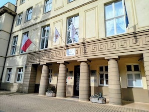 A building with a medical spa sign, multiple flags, and a classical architectural design with columns. - Solanki Medical Spa (Inowrocław)