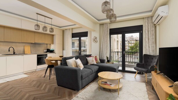 Un salon moderne avec un canapé, une table basse et un téléviseur.