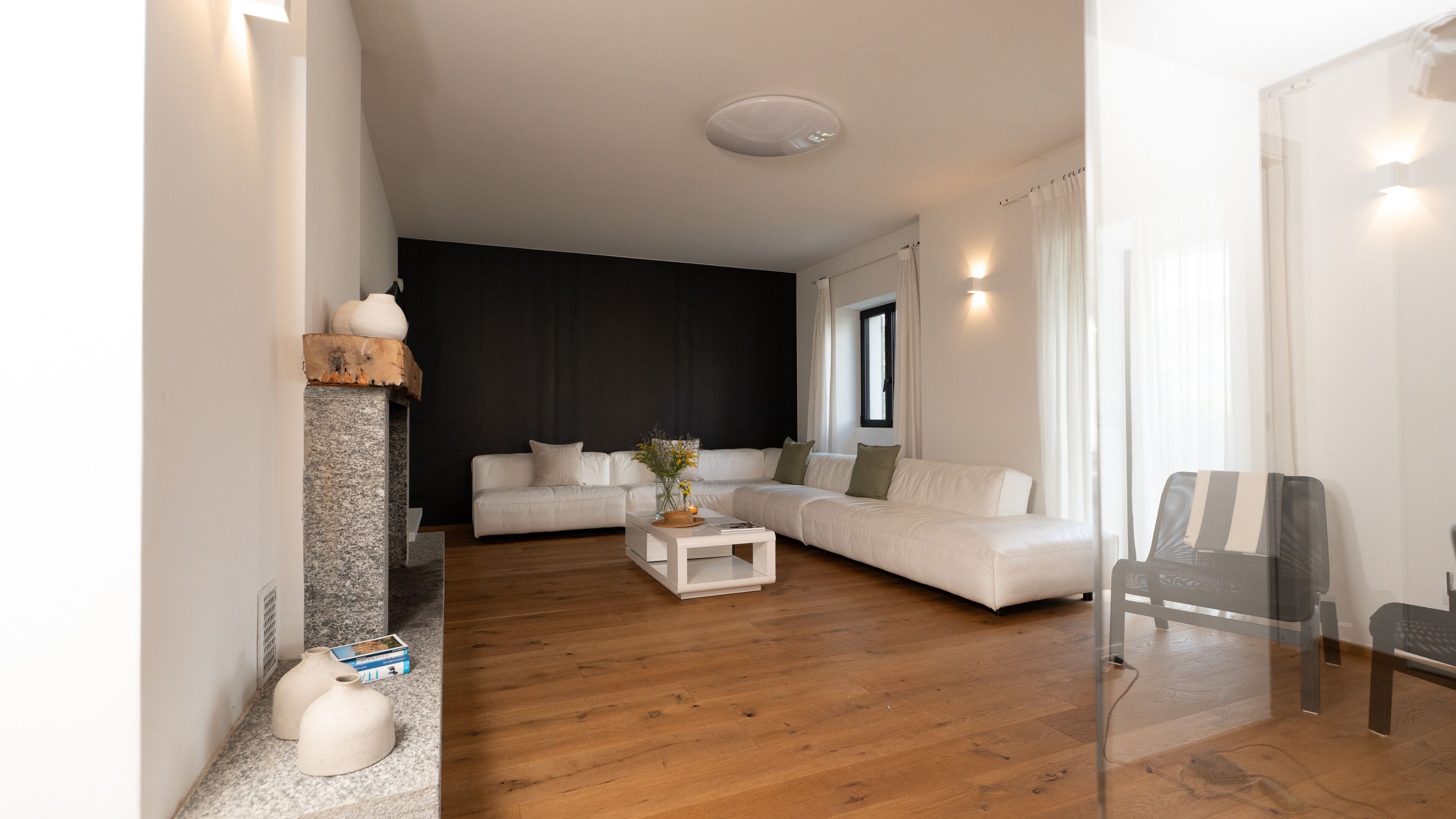Una sala de estar moderna con un sofá blanco, una mesa de centro y una chimenea.