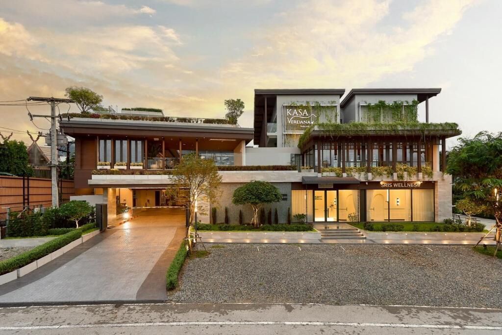 A modern building with a restaurant named 'Kasa Verdiana' and a wellness center named 'Sris Wellness.'