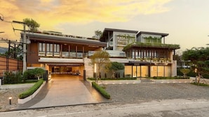 Un hotel moderno con entrada cubierta, un centro de bienestar y un jardín en la azotea.