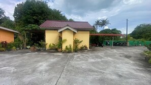 A small building with a tiled roof, surrounded by potted plants and a paved area. - Capital O 91246 Tokman Inn (Langkawi)