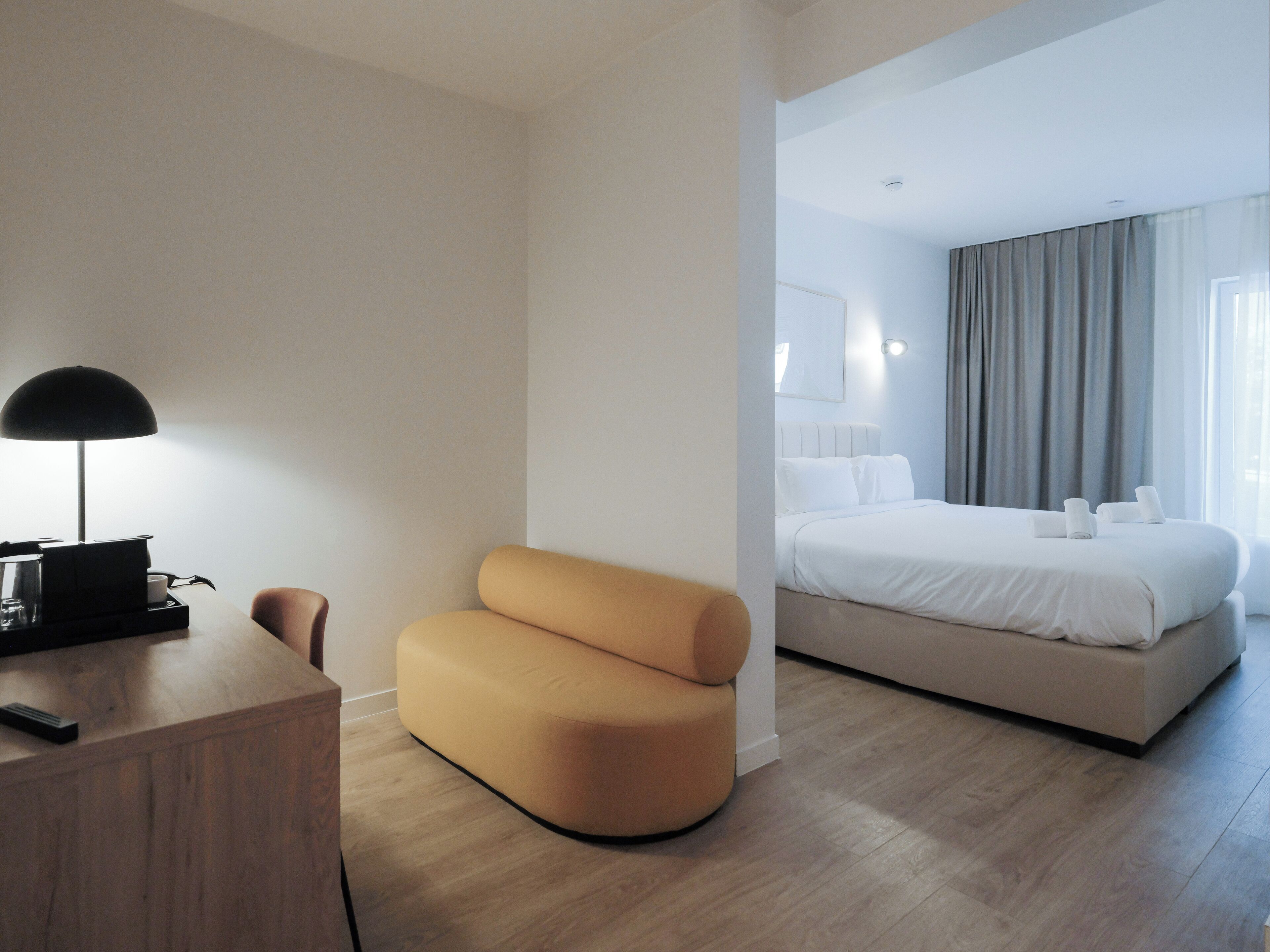 Une chambre d’hôtel équipée d’un bureau, d’une chaise, d’un lit et d’une table de chevet.