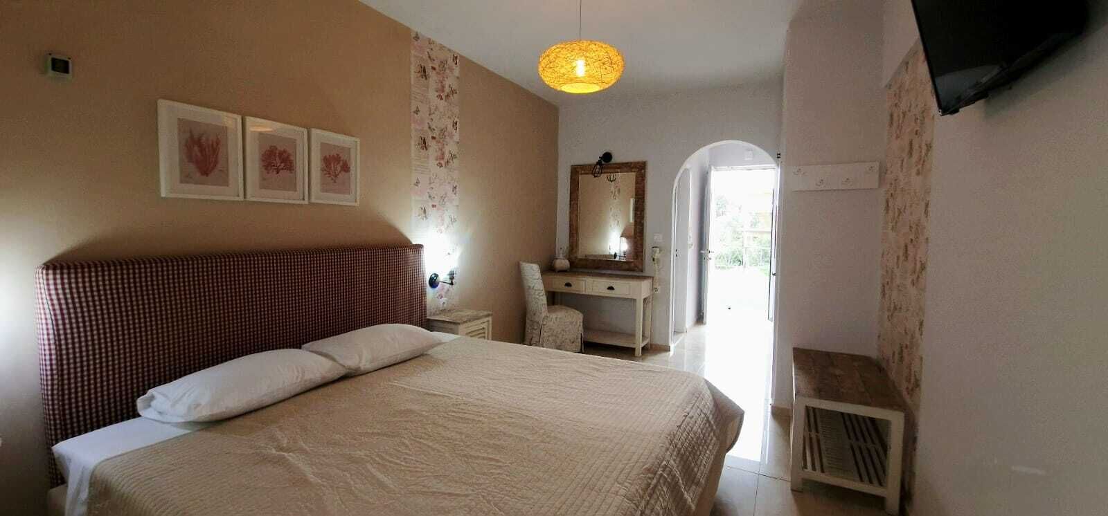 Un dormitorio con cama, cómoda, espejo y lámpara colgante.