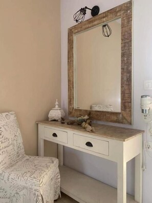 A bedroom with a bed, a bedside table with a lamp, and a large mirror. - PAGONA STUDIO (Rhodes)