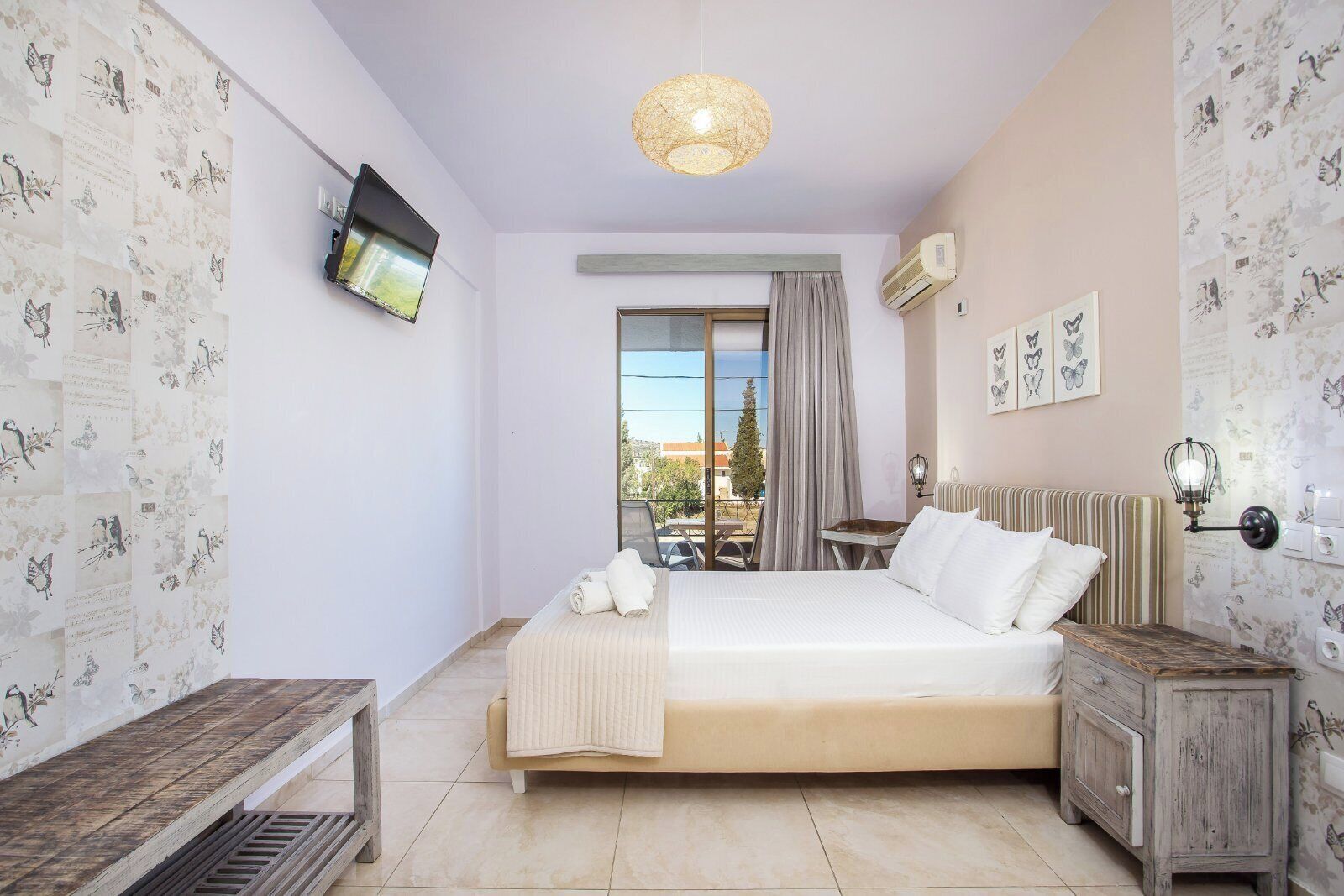 A bedroom with a bed, a bedside table, a lamp, a radiator, and a TV on the wall.