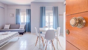 Een moderne kamer met een bed, een eettafel, stoelen en een houten deur met slot.