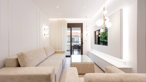 Ein modernes Wohnzimmer mit einer Sofagarnitur, einem Glastisch und einem großen Fenster mit Blick.