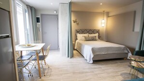 Ein Hotelzimmer mit einem Bett, einem Esstisch mit Stühlen und einem kleinen runden Tisch.