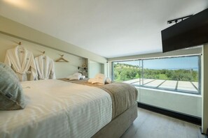 A bedroom with a bed, a TV, a balcony with a view, and a robe rack. - Topaz 2 Bedroom Suite with Private Pool (Pefkochori)