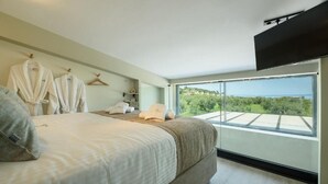 Een slaapkamer met een bed, handdoeken, badjassen en een televisie.
