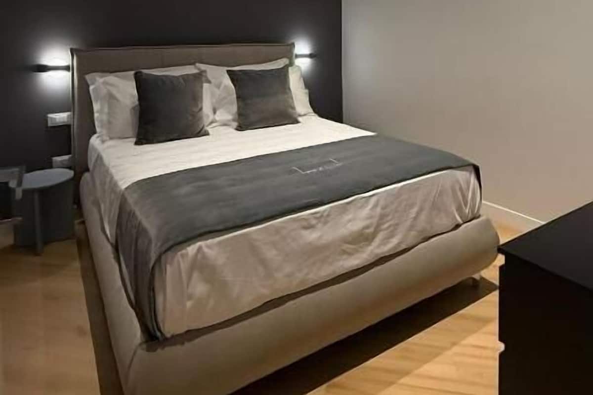 A modern bedroom with a bed, bedside tables, and a nightstand.