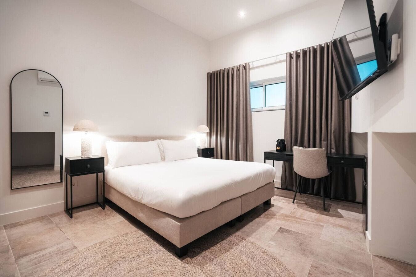 Relax in a cozy king-size bed with a sleek workspace—your perfect retreat at One Mambo-Hotel Unit 1.