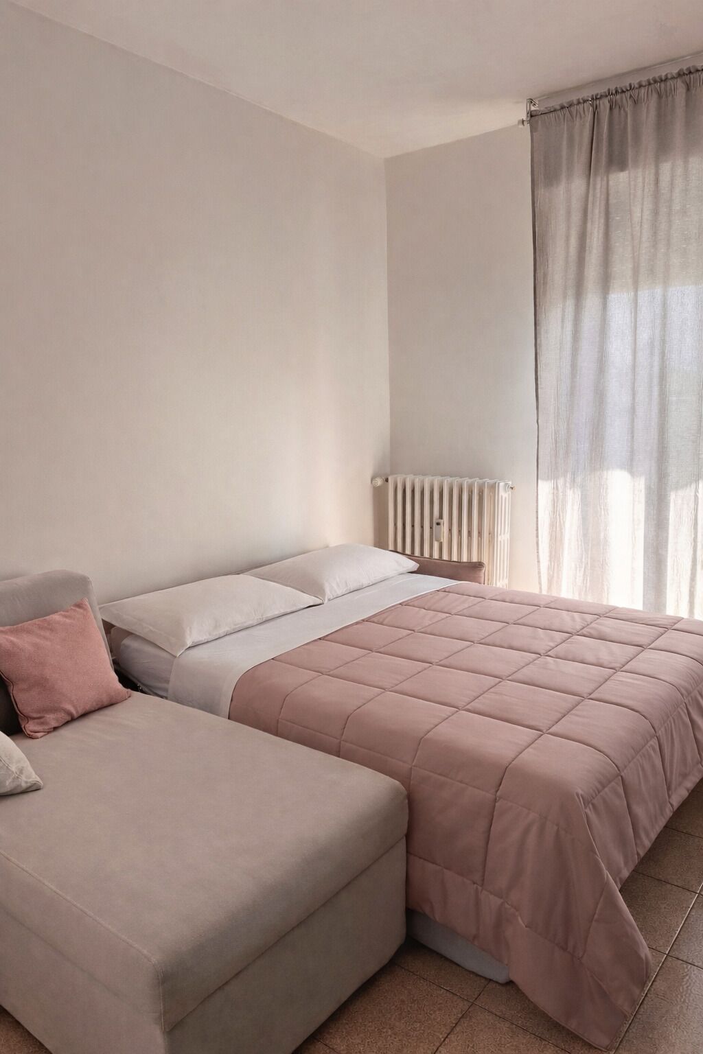 Ein Schlafzimmer mit einem Bett, einem Sofa und einer Heizung.