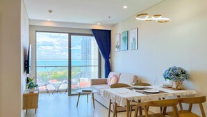 Een moderne woonkamer met balkon, eethoek en uitzicht op de stad.