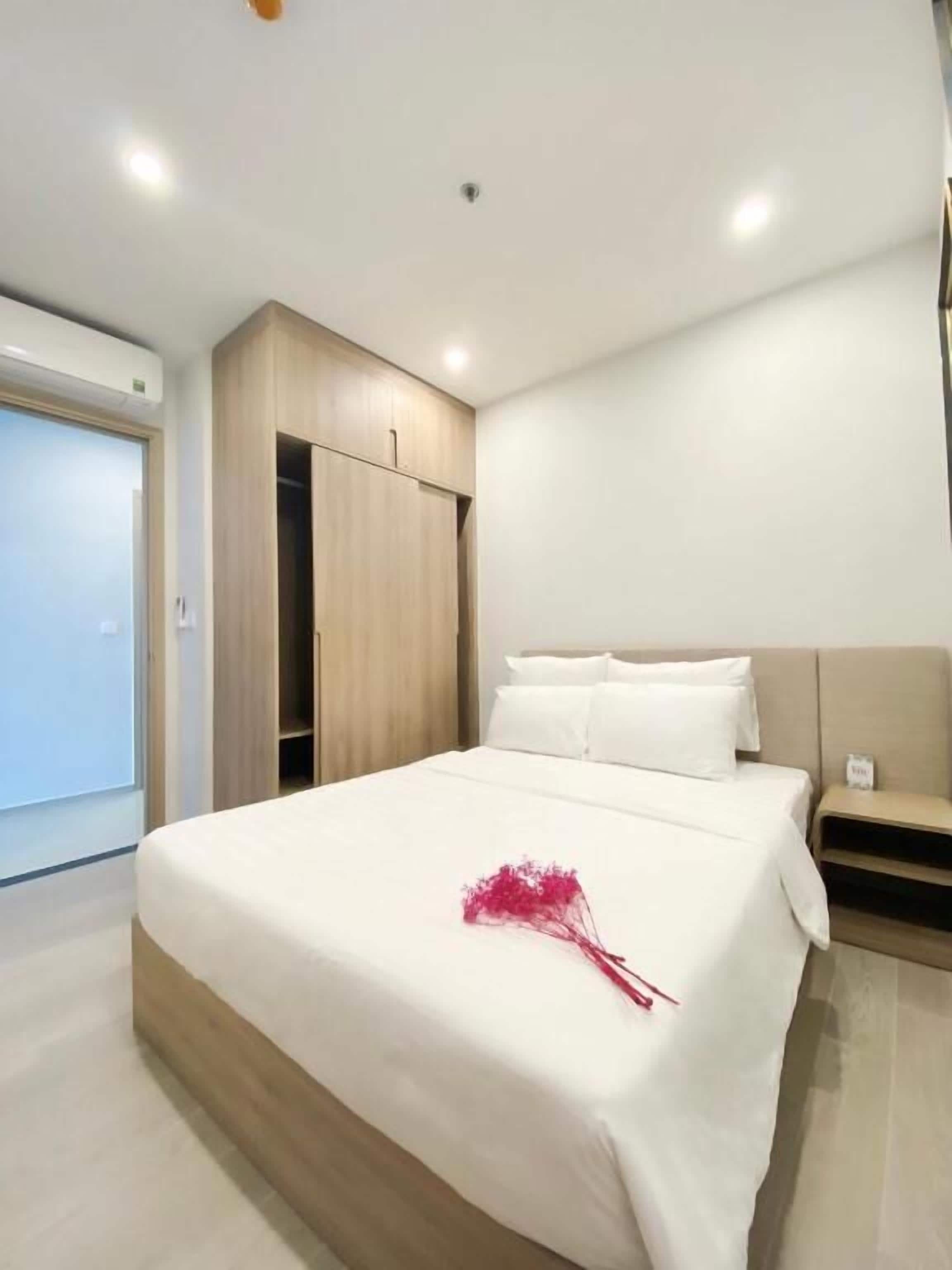 Una habitación de hotel moderna con una cama grande, un armario de madera y un armario empotrado.