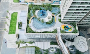 A modern building with a rooftop garden, a circular water feature, and a spiral staircase.