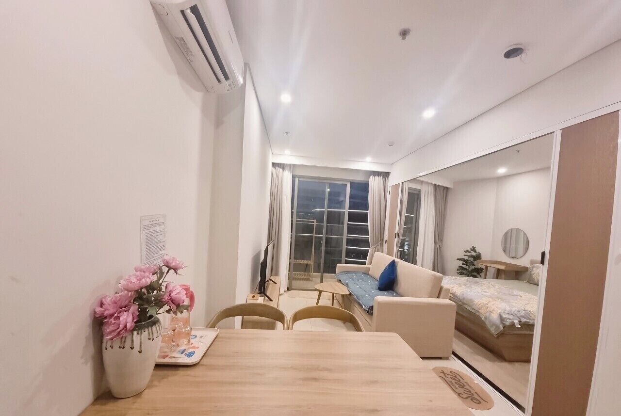 Et moderne værelse med spisebord, stole, sofa og seng.
