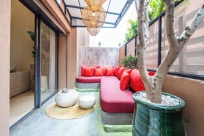 Un interior moderno con un sofá modular, un árbol en maceta y un tapete tejido.