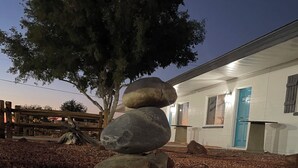 A stack of rocks in a gravel area with a building in the background. - Awesome 1-bedroom apartment with AC in charming Page (Page)