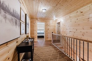A wooden interior with a staircase, a dining area with a table and chairs, and a view of a balcony. - 63-Acre Luxury Estate w/ Creek, Pickleball Court & Golf — 10 Min to Cherokee! (Whittier)