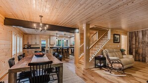 A wooden interior with a dining area, kitchen, and staircase. - 6BR 63 Acre Park Like Estate Loud Creek Trails Pond Huge Yard Pickleball Golf (Whittier)