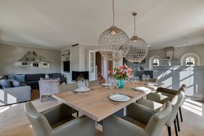 A spacious dining area with a wooden table set for six, surrounded by leather chairs. - Sand Beach - Luxury vacation home Sand Beach in Rantum - with sauna, 450 meters from the beach (Sylt)