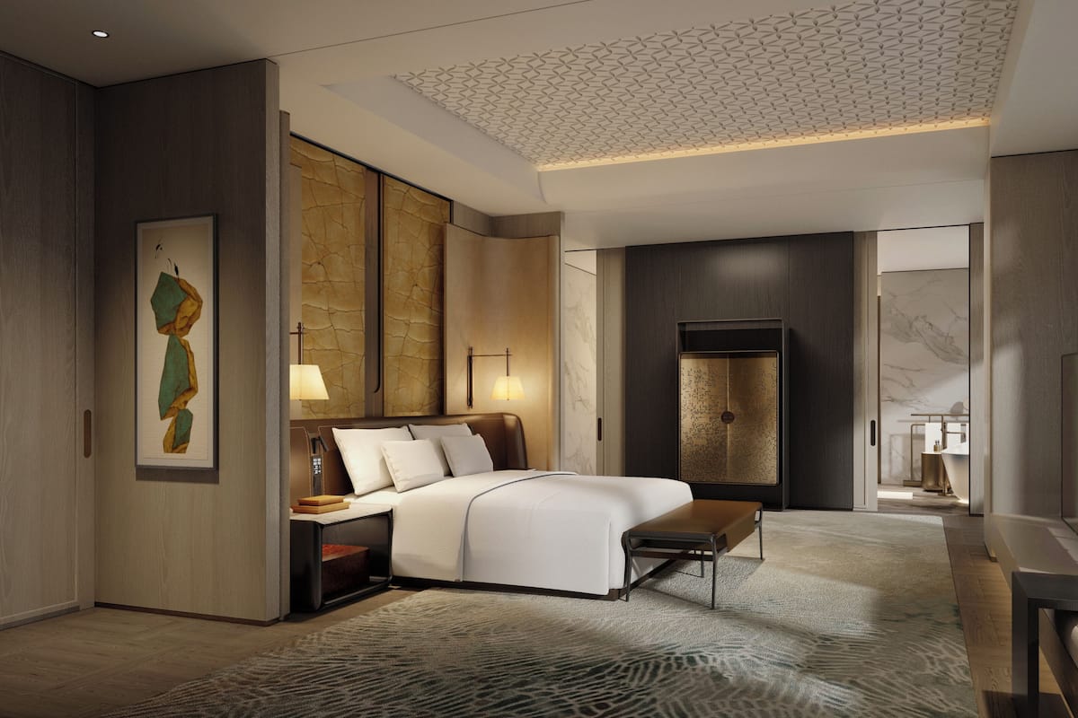 A modern hotel room with a bed, bedside tables, a desk, a chair, a TV, and a large window.