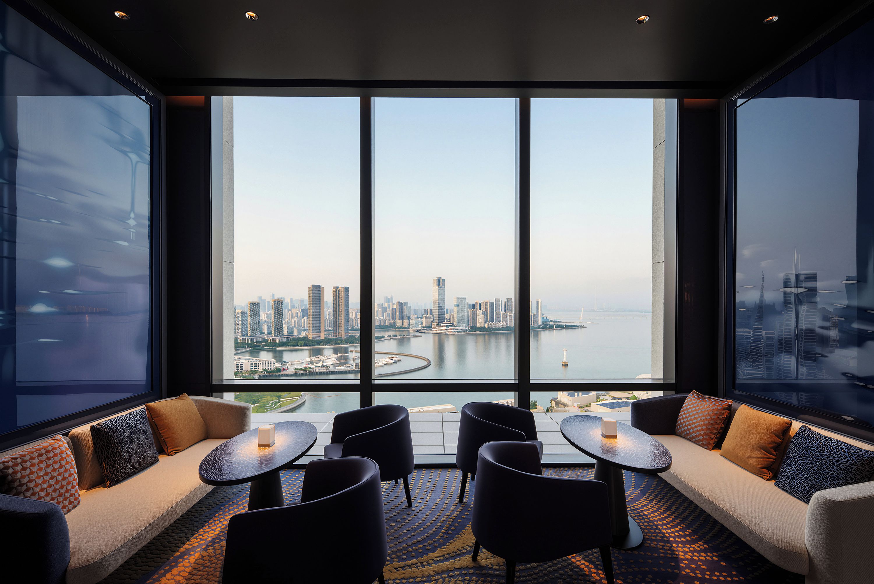 A modern hotel room with a large window offering a city skyline view.