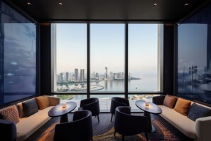 Een moderne hotelkamer met een groot raam en uitzicht op de stadshemel.