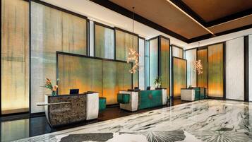 A modern reception area with a reception desk, seating, and decorative lighting.