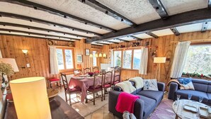 A cozy cabin interior with a dining area, a sofa, and a table with chairs. - Chalet Le Rhônasson by Interhome (Vercorin)